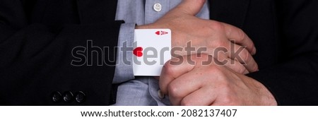 Card ace of hearts in the sleeve of the black suit. Panoramic image Royalty-Free Stock Photo #2082137407