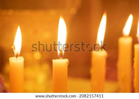 The yellow candles were burning brightly at the feast.