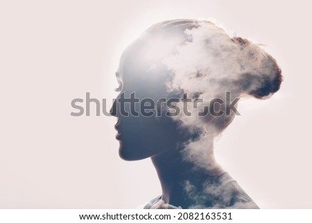 Psychology and caucasian woman mental health concept. Multiple exposure clouds and sun on female head silhouette. Royalty-Free Stock Photo #2082163531