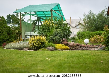 The summerhouse with green roof in the garden. 
