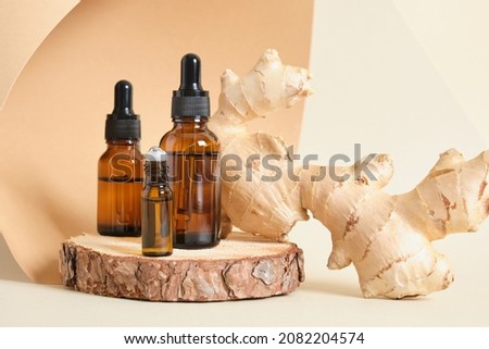 mock up amber glass dropper bottles and ginger root on beige background copy space natural cosmetic concept, bottles with oil or serum on wooden stand, aroma therapy selective focus Royalty-Free Stock Photo #2082204574