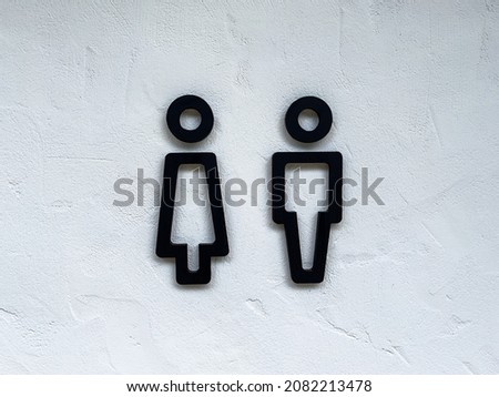 black bathroom symbol on white cement wall
