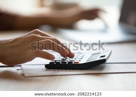 Close up young woman using calculator, managing monthly household budget using e-banking application, doing business or domestic financial paperwork, planning expenditures, economy lifestyle concept. Royalty-Free Stock Photo #2082214123