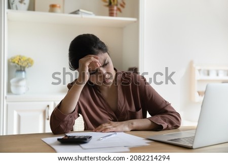 Stressed unhappy young indian woman looking at computer screen, thinking of financial problems, suffering from lack of money for monthly payments, utility bills or mortgage payment, bankruptcy concept Royalty-Free Stock Photo #2082214294