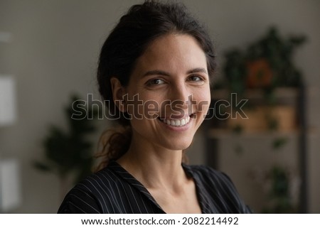 Portrait of smiling motivated young latin woman student worker attractive brunette with beautiful white smile long curly hair done back in bun. Pretty face of happy optimistic casual millennial female
