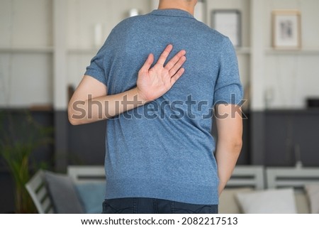 Pain between the shoulder blades, man suffering from backache at home, health problems concept Royalty-Free Stock Photo #2082217513