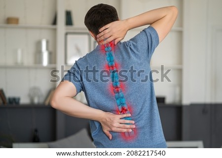 Intervertebral hernia, neck and lumbar pain, man suffering from backache at home, spinal disc disease, painful area highlighted in red Royalty-Free Stock Photo #2082217540