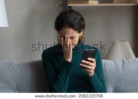 Bad news on screen. Confused frustrated young latin lady cover face with palm turn away from cell seeing important call missed. Desperate millennial woman get message on phone about dismissal from job Royalty-Free Stock Photo #2082220708