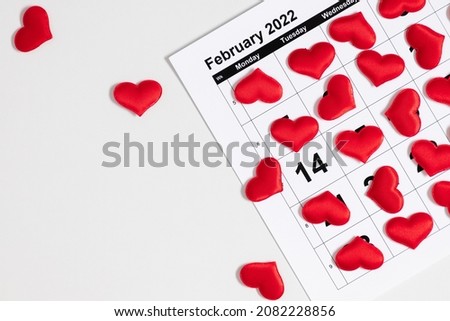 Valentines day background. Office table. Date February 14 on calendar 2022, Valentine's Day red heart circled. Flat lay, top view, copy space  Royalty-Free Stock Photo #2082228856