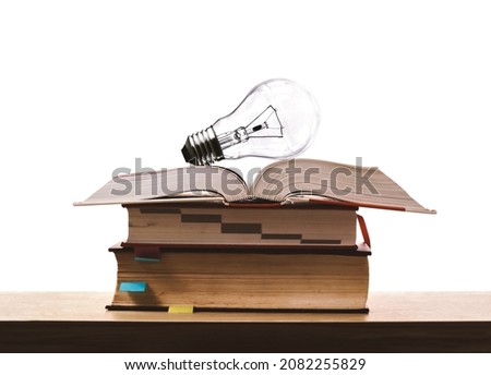 Light bulbs on the stack of old books. Concept of learning, skill enhancement, and academic excellence. Education research. Power of knowledge and wisdom. Creative Idea and studying.