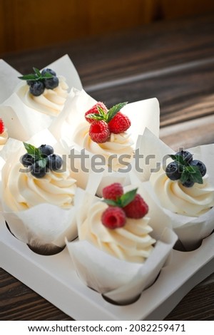 A tray with cones of cream cakes with berries.