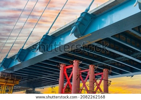 Fragment of a new cable-stayed road bridge at sunset. Desktop background picture. Road traffic, modern bridge crossing. 