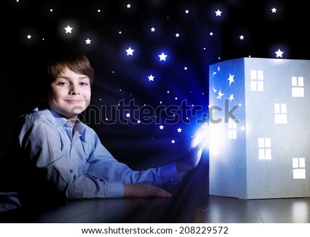 Cute little boy looking at model of house