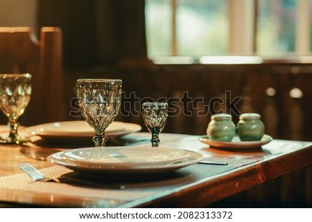 Closeup of drinking glass and reserved table in restaurant with windows behind