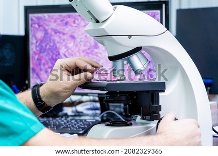 Laboratory assistant works with microscope at the modern laboratory. Royalty-Free Stock Photo #2082329365