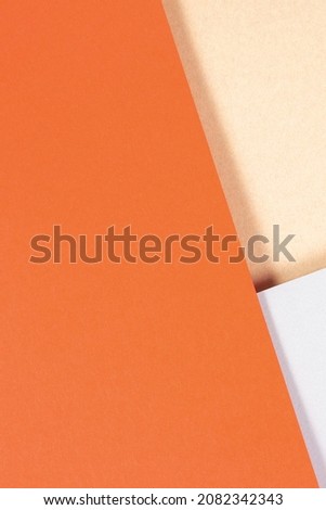 Creative abstract geometric brown craft paper and colored paper background in orange, light gray colors. Top view, copy space.