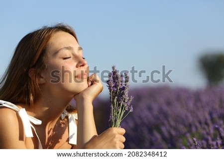 Relaxed female holding bouquet resting in lavender field Royalty-Free Stock Photo #2082348412