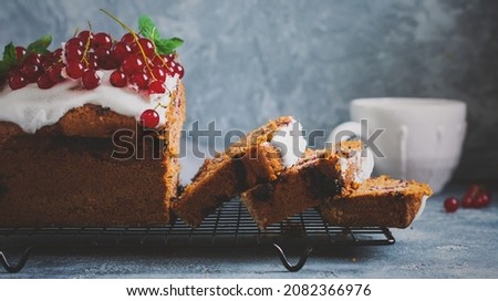 Bundt, muffins or Banana bread cake with glaze and red currant on gray concrete vintage background. Toned image. Top view