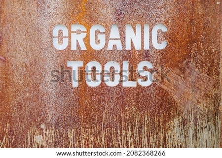 Vintage rusty metal plate with Organic Tools inscription