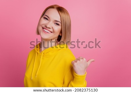 Photo of cheerful blonde lady indicate thumb blank space novelty wear white t-shirt isolated on pink background