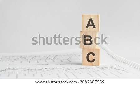 ABC - letters on wooden cubes. concept on cubes and diagrams on a green background. Business as usual concept image. space for text in left. front view concepts