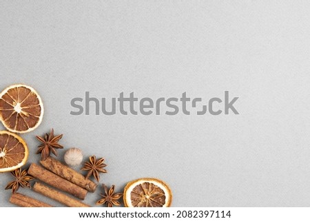 dried orange, cinnamon sticks, star anise and walnut on a gray background, the basis for a Christmas and New Year greeting card in 2022 with copy space