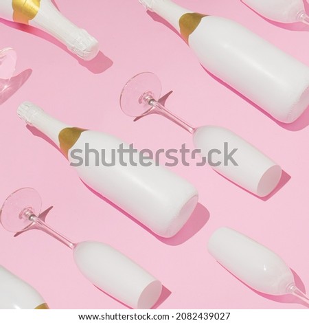 Trendy Christmas pattern with bottles and glasses of champagne against pink background. Minimal New Year party concept.