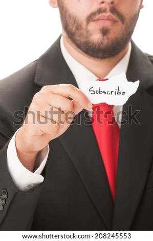 Subscribe concept using a man wearing a black suit and red necktie and holding a piece of paper with the text subscribe on it.