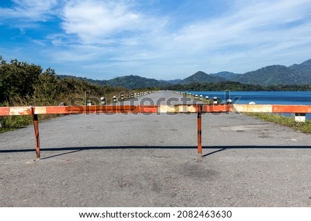 The barrier close the road. loses the passage for cars. Traffic forbidden road sign on a main road. Protected area, entrance is prohibited, passage. Road closed or roadblock.