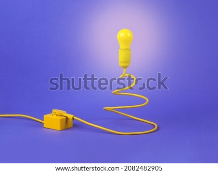 The concept of the New Year. Minimalism. Lamp and cord in the form of a Christmas tree connected to the mains on a purple background.Contemporary art. Place for text.