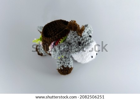 Small-eared donkey with its brown saddlebag. Crochet stuffed animal