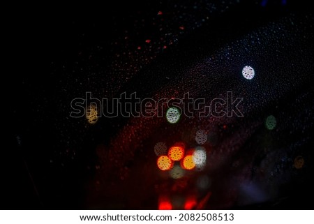 colourful abstract bokeh background from out of focus road and traffic during a rainy night
