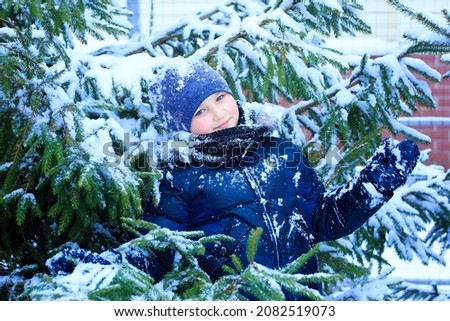 child girl playing with snow in the winter forest, bright snowy fir trees, beautiful nature. High quality photo