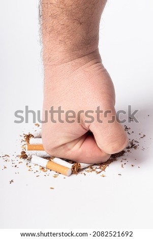 a human hand. the man on her hair. clenched into a fist, and a blow to the broken cigarettes. on a white background. close-up,