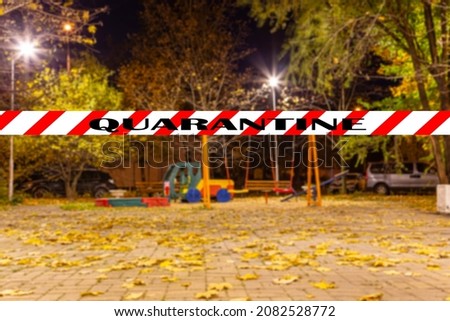 Coronavirus in Moscow, Russia. An empty playground on an autumn night in one of the residential areas (blurry view). Quarantine sign. Concept of COVID pandemic and travel