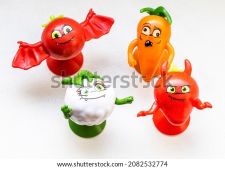 Small children's figurines of vegetables close-up on a white background.