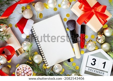 Christmas flat lay with makeup cosmetic products on gray concrete background with copy space. Happy new year 2022 and merry xmas mockup