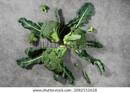 Broccoli inflorescences on laid out on a gray background, top view. Healthy vegetable products, food delivery from farms
