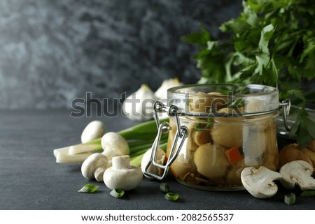 Concept of tasty food with marinated mushrooms on dark wooden table