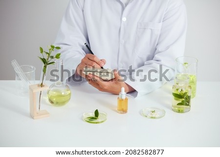 Plants and flowers extract in petri dish and a white background in laboratory , green leaf  in a test tube and doctor for cosmetic advertising , photography science concept
