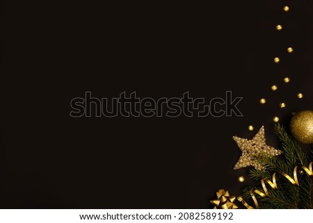 Christmas background with fir branches, gold decorations and pine cones on a black table. Flat lay. top view with copy space. High quality photo