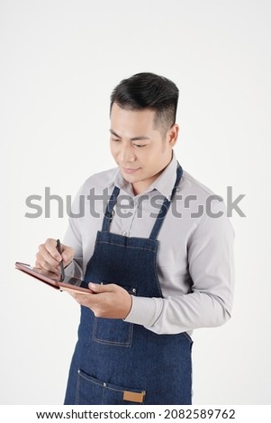 Studio portrait of coffeeshop owner using tablet computer when ordering supplies, coffee and milk delivery online
