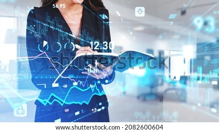 Office woman hands writing in business papers. Blue icons hologram of digital interface, bar chart and stock market data. Concept of financial analysis and advisor