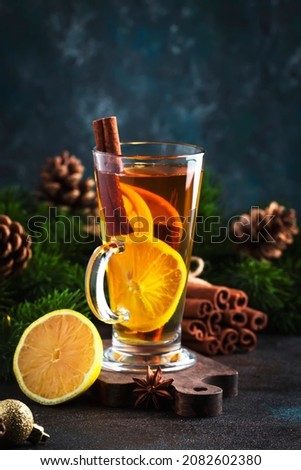 Hot winter tea drink, spicy cocktail with lemon, rum, cinnamon, anise. Rustic style, copy space. Christmas table setting