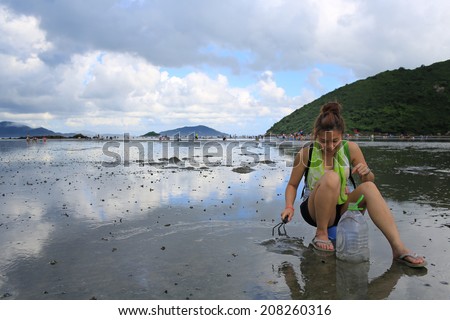 clam digging on mud beach in Lantau island, hong kong china Royalty-Free Stock Photo #208260316