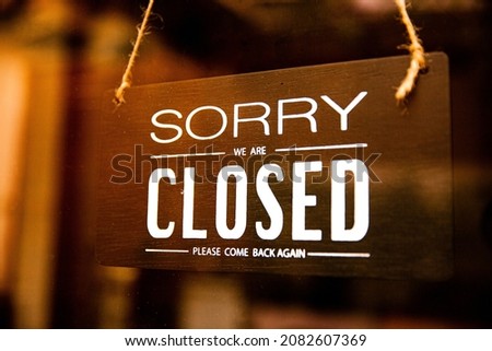 Sorry we are closed black wooden signage with blurred blackground to lockdown covid-19.