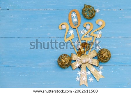 2022 new year, golden numbers on a blue wooden background, gold ribbon bow, Christmas background, new year wallpaper.
