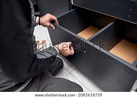 Handyman making kitchen wall cabinets in the apartment. Royalty-Free Stock Photo #2082618739