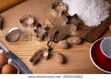 preparing for christmas. everything for gingerbread - molds, flour, eggs on a wooden table
