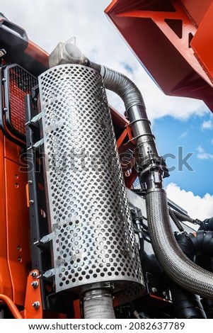 an air filter and a running truck engine against the background of clouds